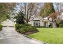 A charming white brick home with a detached garage and a well-maintained lawn and stone-lined driveway at 2374 Havenridge Nw Dr, Atlanta, GA 30305