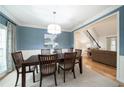 Elegant dining room with a large table, blue accent wall, white trim, and hardwood floors at 4910 Hunters Oaks Ln, Alpharetta, GA 30009