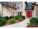 Inviting front entrance with a red door, manicured bushes, and a stone and siding exterior at 4910 Hunters Oaks Ln, Alpharetta, GA 30009