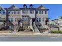 Attractive townhome featuring a brick facade, landscaped front yard, and welcoming entrance at 4498 Dunblane Ave, Sugar Hill, GA 30518