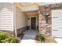 Inviting front entrance with stone accents, a covered porch, and manicured landscaping at 4902 Pleasantry Way, Acworth, GA 30101