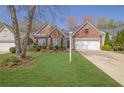 Beautiful brick home with manicured lawn, charming curb appeal, and a convenient two-car garage at 6560 Waveland Dr, Cumming, GA 30040