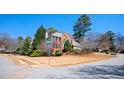 Corner lot featuring a two-story brick house with a two-car garage and mature trees at 1439 Evers Pl, Lawrenceville, GA 30043