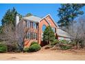 Attractive two-story red brick home with a two-car garage and mature trees at 1439 Evers Pl, Lawrenceville, GA 30043