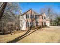 Well-maintained brick home with black shutters, offering a classic and inviting curb appeal with mature trees at 2050 Federal Rd, Roswell, GA 30075