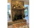 Close-up of a stone fireplace with a wooden mantel and decorative plants at 8740 Roswell Rd # 5G, Sandy Springs, GA 30350