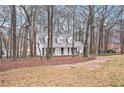 Exterior view of this charming home on a wooded lot with mature trees and a circular driveway at 3780 Clubview Se Ct, Conyers, GA 30094