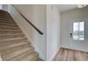 A carpeted staircase leading to the upper level sits beside the entryway with luxury vinyl plank flooring at 4604 Eastbrook Pl, Snellville, GA 30039