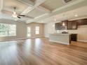 Open-concept living room boasts luxury vinyl plank flooring, coffered ceilings, and dark cabinetry at 4604 Eastbrook Pl, Snellville, GA 30039