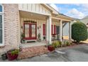 Charming brick front porch with double doors, red shutters, and brick stairs at 9620 Coastal Pointe Dr, Villa Rica, GA 30180