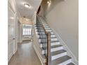 Hallway staircase with hardwood floors and modern black railings at 112 Calder Dr, Alpharetta, GA 30009