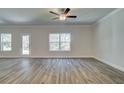 Spacious living room features hardwood flooring, a ceiling fan, and natural light from large windows at 4594 Eastbrook Pl, Snellville, GA 30039