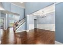 Open living room with hardwood floors, staircase and an elegant chandelier enhancing the space at 1761 Brandemere Dr, Austell, GA 30168