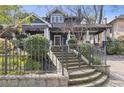 Beautiful home with a stone wall, manicured lawn, and decorative wrought iron fence at 289 9Th Ne St, Atlanta, GA 30309