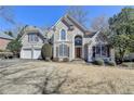 Charming two-story home with a well-manicured lawn and inviting curb appeal on a sunny day at 4260 River Club Dr, Cumming, GA 30041