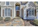 Close-up of the inviting front entrance with stone walkway, tall windows, and a stylish front door at 4260 River Club Dr, Cumming, GA 30041
