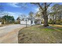 Wide view of the renovated home showing driveway, yard, and basketball hoop at 2711 Mcdonough Rd, Hampton, GA 30228