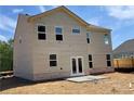 Back exterior of home with beige siding, patio, and a level grassy backyard at 3387 Wild Clary Court Lot 20, Buford, GA 30519