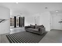 Bright living room with modern flooring, a stylish rug, and large windows at 708 Mill Pond Se Dr, Smyrna, GA 30082