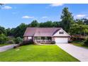 Traditional home with brick facade, a covered porch, and a well-kept lawn under a blue sky at 144 Bobs Sw Dr, Mableton, GA 30126