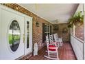 Cozy front porch featuring brick walls, white rocking chairs, and a decorative glass front door at 144 Bobs Sw Dr, Mableton, GA 30126