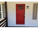 Close-up of the red front door with a glass pane and black lantern at 147 Mildred Ct, Dallas, GA 30157