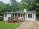Quaint home boasts inviting front deck, tidy lawn, and a red front door at 147 Mildred Ct, Dallas, GA 30157