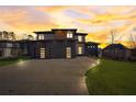 Contemporary home with a modern design, three-car garage, and striking sunset backdrop at 2551 Kilgore Rd, Buford, GA 30519