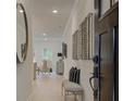 Bright hallway showcasing modern art, decorative mirror, seating, and an open view into the home at 121 Priestwood Ln, Acworth, GA 30102