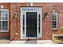 Elegant black front door surrounded by brick and sidelight windows at 4831 Edinburgh Dr, Smyrna, GA 30082