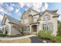 Beautiful home with a stone-accented facade, manicured lawn, and inviting front entrance at 5825 Laurel Oak Dr, Suwanee, GA 30024