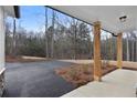 Spacious driveway leading to a charming home with a covered entryway and a view of the wooded surroundings at Tract3 Harmony Rd, Temple, GA 30153