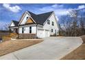 New two-story home featuring a three car garage, stone accents, and a long concrete driveway at 64 Roberson Ne Dr, Cartersville, GA 30121