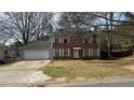 Two-story brick home with a two-car garage, situated on a grassy front lawn at 1226 Samuel Dr, Norcross, GA 30093