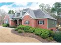 Beautiful red brick home with an attached garage, lush landscaping, and mature trees at 9445 Grande Dr, Winston, GA 30187