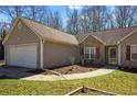 A charming single-story home with stone accents, a two-car garage, and a walkway to the front door at 145 Alcovy Cir, Covington, GA 30014
