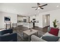 Open-concept living space with modern furnishings, hardwood floors, and a ceiling fan, flowing into a stylish kitchen at 407 Newland Way, Acworth, GA 30102