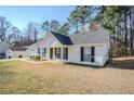 The side of this single-story house features white siding and an expansive lawn at 835 Old Rocky Rd, Atlanta, GA 30349