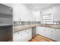 Bright kitchen featuring white cabinets, stone countertops, and stainless-steel appliances at 2533 Briers North Dr, Atlanta, GA 30360