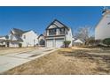 Charming two-story home with a two-car garage and manicured front yard on a sunny day at 3291 Quincey Xing, Conyers, GA 30013