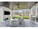 This covered patio features a beautiful stone fireplace, seating area, and outdoor bar with a view of the lake at 1460 Lakemist Ct, Roswell, GA 30075