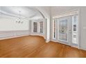 Bright foyer with hardwood floors, elegant chandelier, and decorative wall trim at 2528 Picket Fence Ln, Snellville, GA 30078