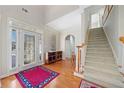 Bright foyer with hardwood floors, staircase, and decorative glass door at 2528 Picket Fence Ln, Snellville, GA 30078