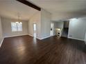 Open-concept room featuring beautiful wood floors, vaulted ceilings, and a staircase to the upper level at 3335 New Heritage Dr, Johns Creek, GA 30022