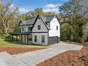 Modern farmhouse with attached garage and concrete driveway on a large landscaped lot at 2788 Browns Mill Se Rd, Atlanta, GA 30354