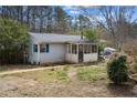 Side view of a one-story home with light siding, and a screened-in porch at 6219 Holly Ann Se St, Acworth, GA 30102