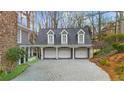 A detached three-car garage with a spacious parking area, stone pillars, and landscaping at 4655 Jett Rd, Atlanta, GA 30327