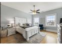 Bright main bedroom with ample natural light, hardwood floors, and a classic white bed frame at 5821 Clarion St # J8, Cumming, GA 30040