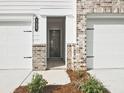 Exterior shot showing the front entrance with a brick facade and two-car garage at 4651 Larkfield Way, Powder Springs, GA 30127