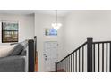 Bright entryway with stairs and a modern light fixture welcomes you to the open and airy living space at 7316 Caribou Trl, Riverdale, GA 30296